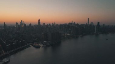 East River 'ın üzerinde Manhattan' ın New York şehrinin Skyline in Beautiful Dawn Sunset Orange Light 'ı var. 