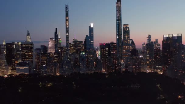 AERIAL: Manhattan Skyline por la noche con luces parpadeantes en la ciudad de Nueva York en Central Park — Vídeos de Stock