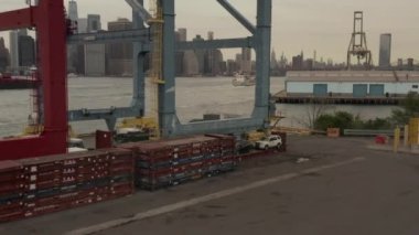 Bulutlu bir günde New York şehrinin silueti ve doğu nehri boyunca uçan büyük mavi kargo endüstriyel vinç. 
