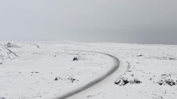 AERIAL: Over Snow White Landscape with Road, Mountain in Iceland Winter, Snowing, Cold, Arctic — 비디오