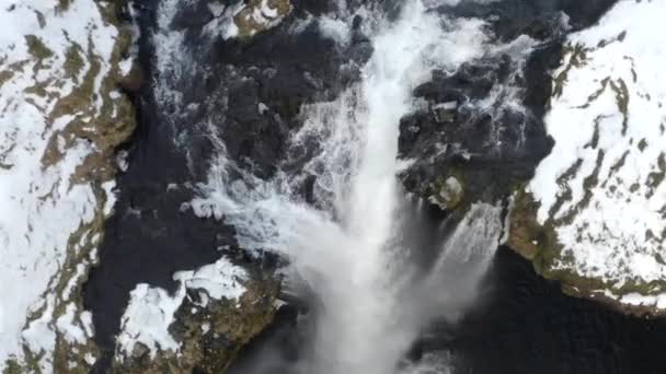 AERIAL: Close-up van de waterval in de sneeuw, IJskloof in IJsland Green Grass, bewolkt — Stockvideo