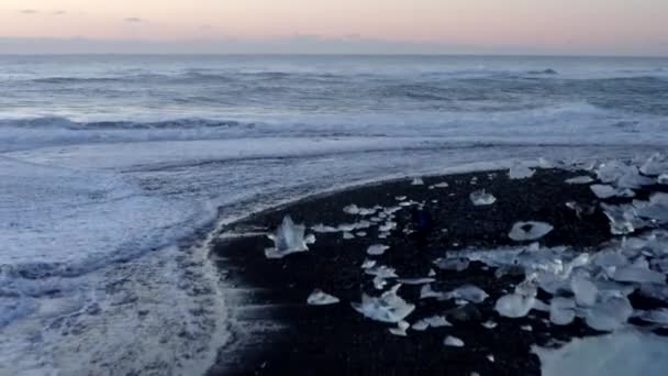 AERIAL: Flying over Diamond Beach, Black Beach in Iceland in Winter Snow, Ice, Waves, Water — Stock video