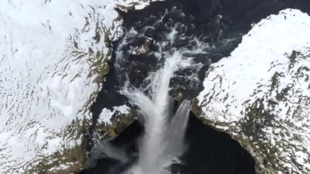 AERIAL: Nahaufnahme von Wasserfall im Schnee, Eisschlucht in Island Grünes Gras, bewölkt — Stockvideo