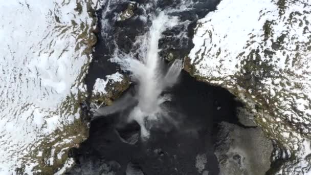 AERIAL: Närbild av vattenfall i snö, Ice Canyon på Island grönt gräs, molnigt — Stockvideo