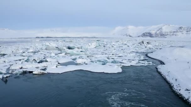 AERIAL: Volando hacia los témpanos nevados en Islandia Lago Invierno, Nieve — Vídeos de Stock