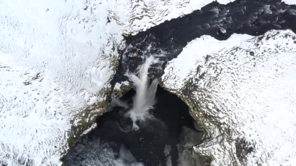 AERIAL: Közel a vízesés hó, Ice Canyon Izlandon zöld fű, felhős — Stock videók