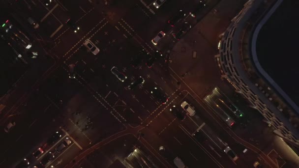 AERIAL: Schöne Überkopfaufnahme einer vielbefahrenen Kreuzung in der Nacht mit Autoverkehr und Stadtampeln — Stockvideo