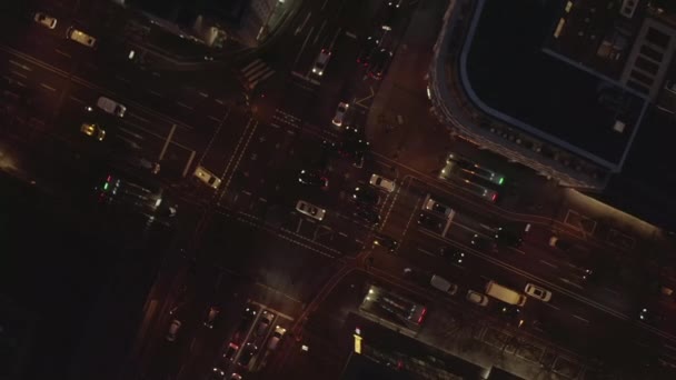 AERIAL: Schöne Überkopfaufnahme einer vielbefahrenen Kreuzung in der Nacht mit Autoverkehr und Stadtampeln — Stockvideo