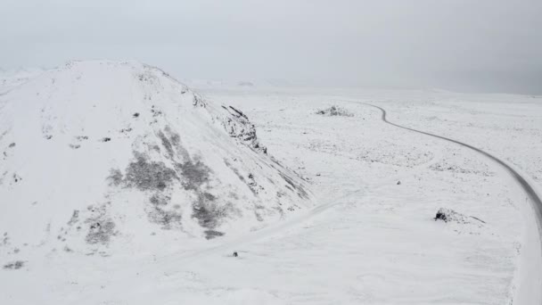 AERIAL: Rumo à Montanha Branca de Neve com Pedras Negras na Islândia Inverno, Neve, Frio, Ártico — Vídeo de Stock