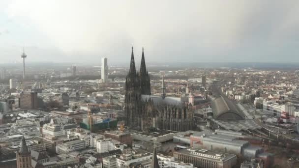 AERIAL: Naar de prachtige kathedraal van Keulen met centraal station in mooi wazig zonlicht — Stockvideo