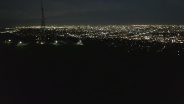 AERIAL: Espectacular vuelo sobre Mount Lee y Hollywood firman por la noche con luces del paisaje urbano de Los Ángeles — Vídeos de Stock