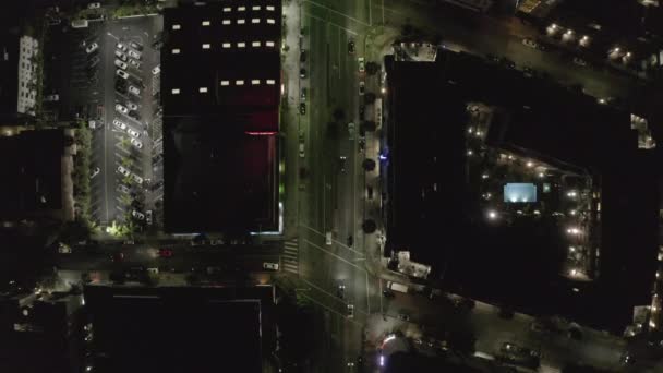 AERIAL: Vista aérea na Wilshire Boulevard Street em Hollywood Los Angeles à noite com ruas brilhantes e luzes de trânsito da cidade — Vídeo de Stock