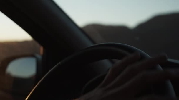 SLOW MOTION: EPIC CLOSE UP OF HAND TURNING ON STEARING WHEEL ON SUNSET — Stock Video