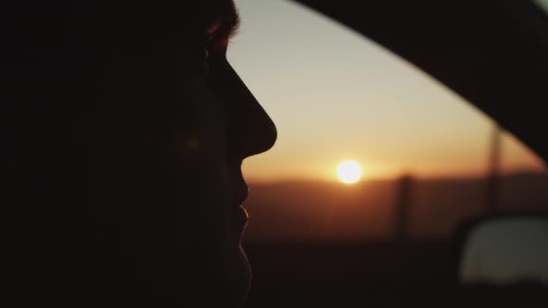 SLOW MOTION: EPIC CLOSE UP OF YOUNG MAN SILHOUETTE IN DRIVERSAT OP SUNSET — Stockvideo