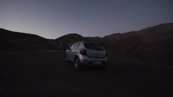 Silver SUV αυτοκίνητο οδήγηση πάνω από DIRT σε MOUNTAINS νωρίς το πρωί — Αρχείο Βίντεο