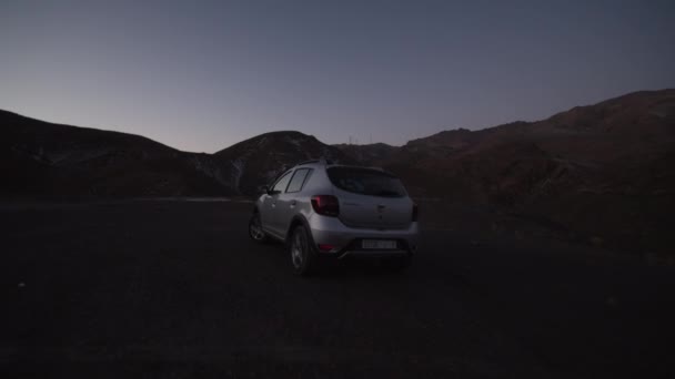 SLOW MOTION: Silver SUV αυτοκίνητο οδήγηση πάνω από το diret σε mountains νωρίς το πρωί — Αρχείο Βίντεο