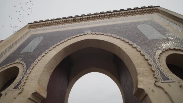 SLOW MOTION: SCHÖNE ALTE ARCHWAY, GATE IN MOROKO ALTSTADT MIT VÖGEL, die am Himmel vorbeifliegen — Stockvideo