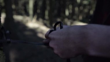 Yaz güneşinde ormanda elinde ip kullanan bir adam. 