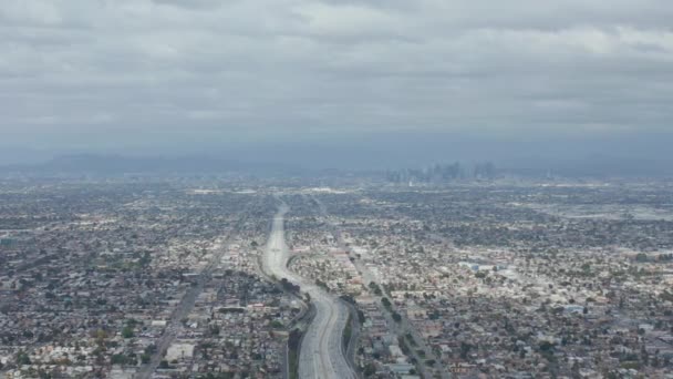 АЭРИАЛ: Спектакльный вид на Лос-Анджелес, Калифорния, с большой автомагистралью, соединяющей центр города в пасмурный день — стоковое видео