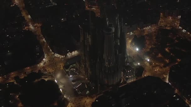 AERIAL: Tiro largo de La Sagrada Familia à noite brilhando em Barcelona bonita, Espanha — Vídeo de Stock