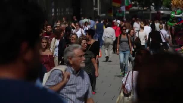 Толпа людей, идущих по торговой улице, тематический парк летом разнообразие одежды, различные языки народов — стоковое видео
