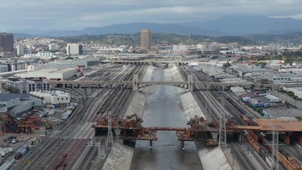 AERIAL: Uitzicht over de Los Angeles River Bridge wordt gebouwd onder Construction Site met bewolkte bewolkte lucht — Stockvideo