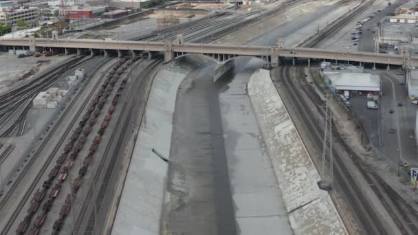 AERIAL: Rio Los Angeles com água no céu nublado nublado ao lado de trilhas de trem — Vídeo de Stock