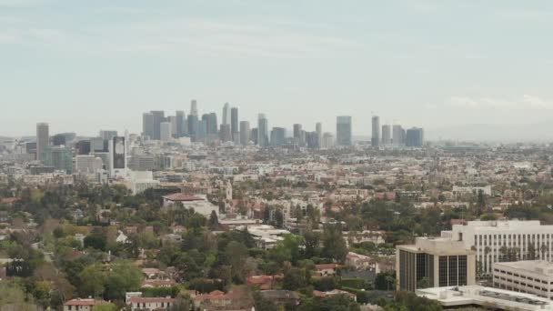 AERIAL: Vista sobre Los Ángeles, California con el centro en el fondo y hermosos árboles verdes ricos y casas residenciales en el día nublado — Vídeos de Stock