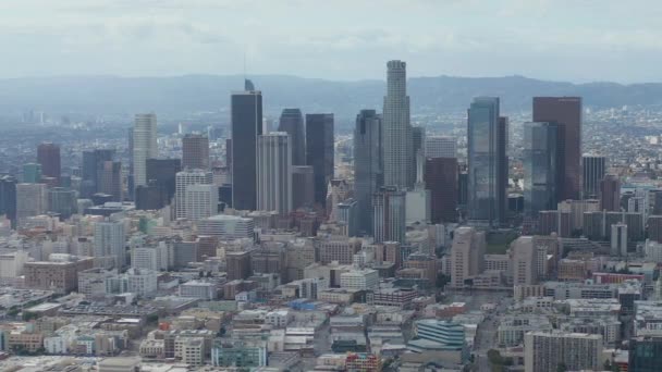 AERIAL: Círculo lento en el centro de Los Ángeles Skyline con Warehouse Art Distrct en primer plano con cielo azul y nubes — Vídeos de Stock