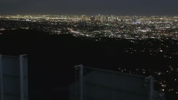 AERIAL: Spectacular Flight over Letter O of Hollywood Sign at Night with Los Angeles City Lights — стокове відео