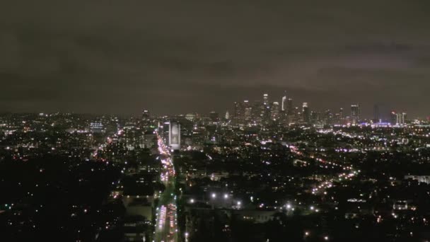 AERIAL: View over Los Angeles at Night with Wilshire Boulevard Glowing Streets and City Car Traffic Lights — Stock Video