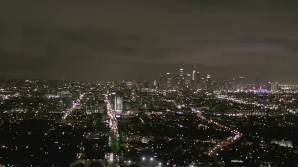 AERIAL: Vista sobre Los Angeles à noite com Wilshire Boulevard Glowing Streets e City Car Traffic Lights — Vídeo de Stock