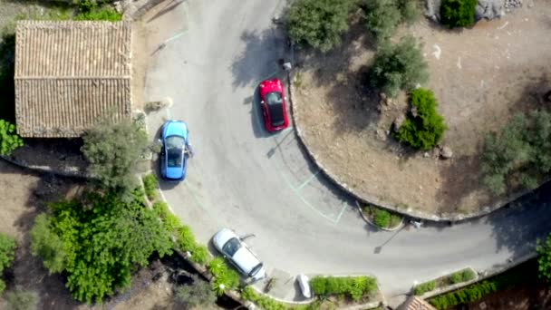 AERIAL: Widok z lotu ptaka czerwonego i niebieskiego samochodu na Hill Road na Tropical Island Mallorca, Hiszpania na słoneczny dzień wakacje, podróże, słoneczny, fale — Wideo stockowe