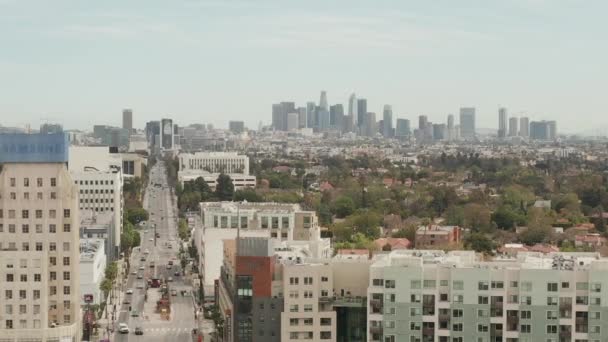 AERIAL: Flug über Wilshire Boulevard in Richtung Downtown Los Angeles, Kalifornien mit Baustelle im Vordergrund am bewölkten Tag — Stockvideo
