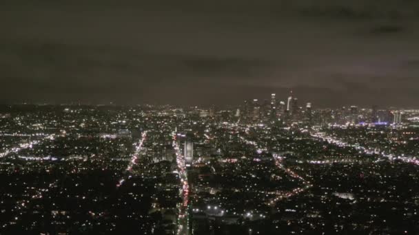 AERIAL: Uitzicht over Los Angeles 's nachts met Wilshire Boulevard Glow Streets en City Car Traffic Lights — Stockvideo