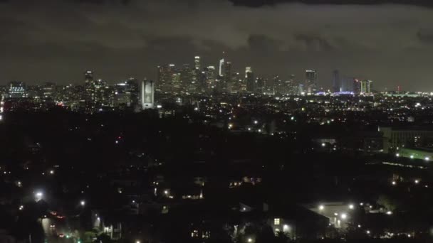 AERIAL: Over Dark Hollywood Los Angeles en la noche con nubes sobre el centro y luces de la ciudad — Vídeo de stock