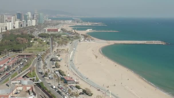 AERIAL: Drone vlucht over het strand van Barcelona op een prachtige zonnige dag met blauwe lucht — Stockvideo