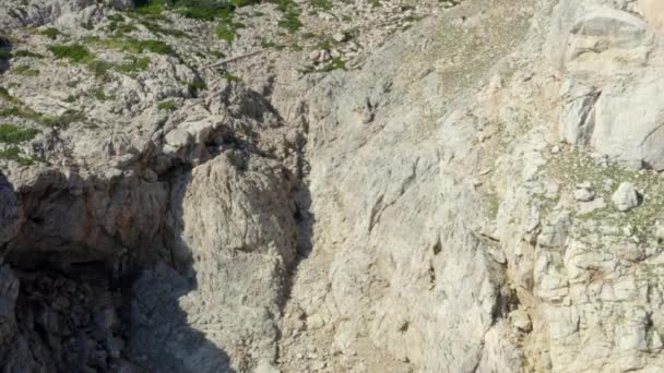 AERIAL: Guy Standing on Edge of Cliff with Blue Water Waves crushing on Tropical Island Mallorca, Spain Vacation, Travel, Sunny, Waves — Stock Video