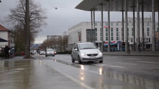MOCIÓN LENTA: Coches que pasan por Rainy Road en Kassel, Alemania Luz del día — Vídeos de Stock