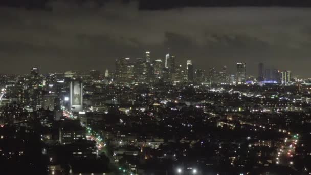 AERIAL: Over Dark Hollywood Los Angeles en la noche con nubes sobre el centro y luces de la ciudad — Vídeos de Stock