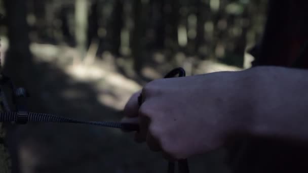 SLOW MOTION: Kerl mit Seil in der Hand im Wald in der Sommersonne — Stockvideo