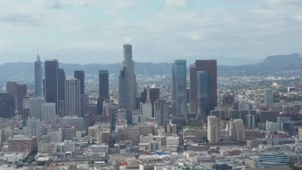 AERIAL: Langsame Seitenaufnahme der Skyline von Downtown Los Angeles mit Lagerhauskunst im Vordergrund mit blauem Himmel und Wolken — Stockvideo