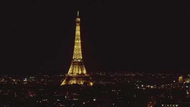 AERIAL: Lentamente Círculo Torre Eiffel, Tour Eiffel en la noche sobre París, Francia con hermosas luces de la ciudad — Vídeo de stock