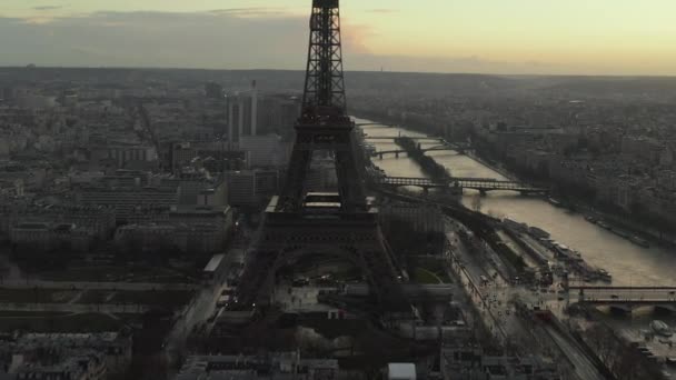 АЭРИАЛ: Беспилотник кружит над Эйфелевой башней, экскурсия по Эйфелевой башне в Париже, Франция с видом на реку Мбаппе в свете заката — стоковое видео