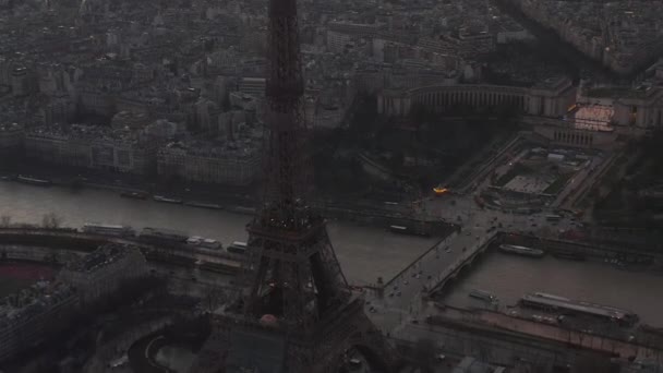 AERIAL: Vuelo en avión no tripulado inverso desde la Torre Eiffel, Tour Eiffel en París, Francia con vista al río Sena con hermosa luz del atardecer — Vídeos de Stock