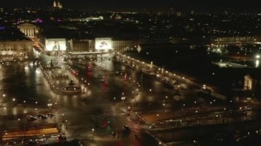 Paris 'teki Place de la Concorde üzerinden gece uçuşu Islak Zemin ve Parlak Şehir ışıklarıyla 