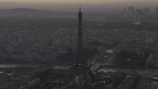 AERIAL: Vuelo en avión no tripulado inverso desde la Torre Eiffel, Tour Eiffel en París, Francia con vista al río Sena y hermoso horizonte de París — Vídeos de Stock