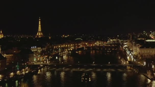 AERIAL: Vista sobre el río Sena por la noche en París, Francia con vista a la Torre Eiffel, Tour Eiffel Luz brillante y hermosas luces de la ciudad — Vídeos de Stock