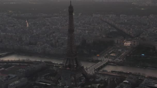 AERIAL: Vuelo en avión no tripulado inverso desde la Torre Eiffel, Tour Eiffel en París, Francia con vista al río Sena con hermosa luz del atardecer — Vídeo de stock