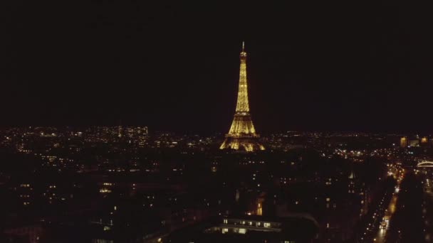 AERIAL: Powoli krążąca wieża Eiffla, Tour Eiffel nocą nad Paryżem, Francja z pięknymi światłami miejskimi — Wideo stockowe